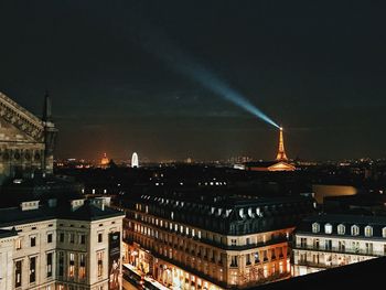 Illuminated cityscape against sky at night