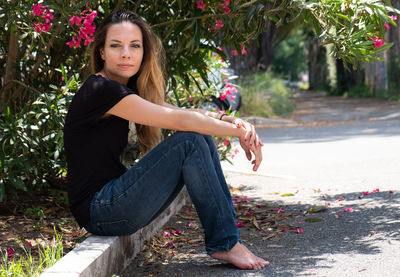 Portrait of young woman sitting on plant