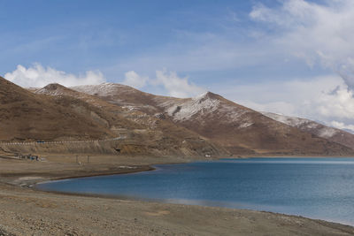 Scenic view of sea and mountains against sky