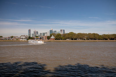 Sea by buildings against sky in city