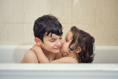 Brothers bathing and playing with foam