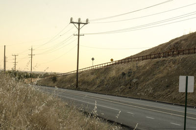 Electricity pylon against sky during sunset