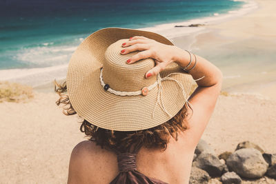 Rear view of woman wearing hat at beach