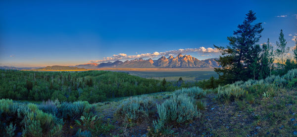 Panoramic view of early sun rays on the grand teton mountain range.