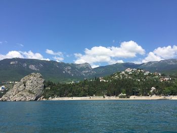 Scenic view of calm sea against mountain range