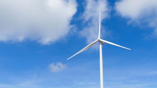 Low angle view of windmill against blue sky