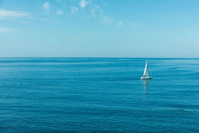 Sailboat sailing in sea against sky