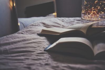 Close-up of open book on bed at home