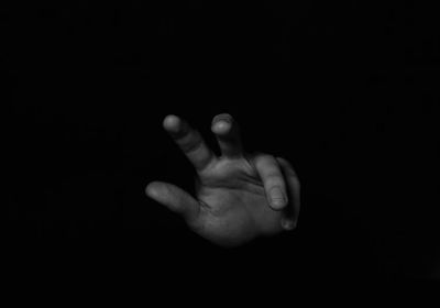 Close-up of human hand against black background