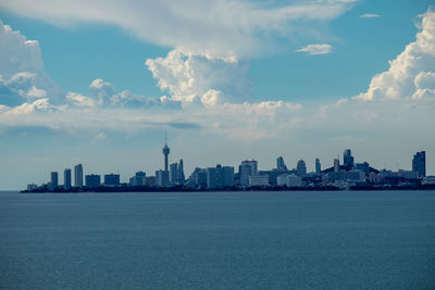 View of buildings in city against cloudy sky