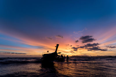 Silhouette boat in sea against sky during sunset