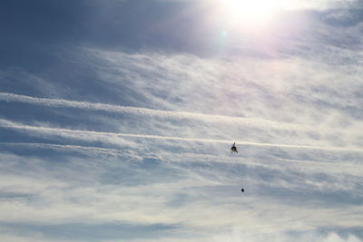 Low angle view of silhouette birds flying against sky