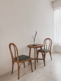 Empty chairs and table against wall at home