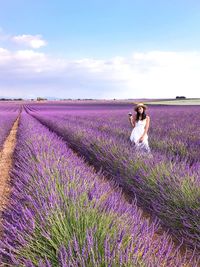 Portrait of woman standing on lavender field