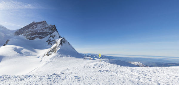 Scenic view of snowcapped mountains against blue sky