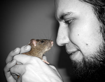 Close-up of man holding rat