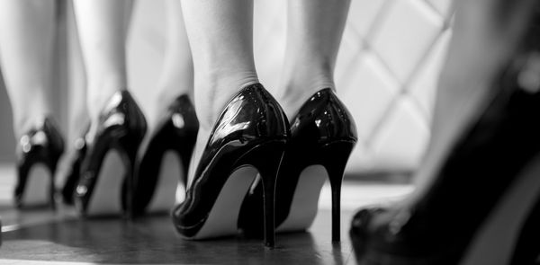 Low section of fashion models wearing high heels 
