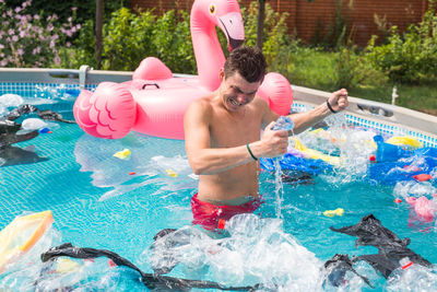 Full length of shirtless man in swimming pool