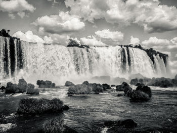 Scenic view of waterfall against sky