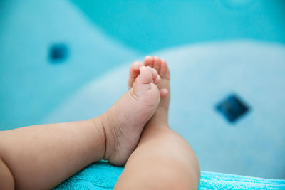 Low section of baby feet in swimming pool