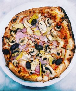 Directly above shot of pizza in plate on wooden table