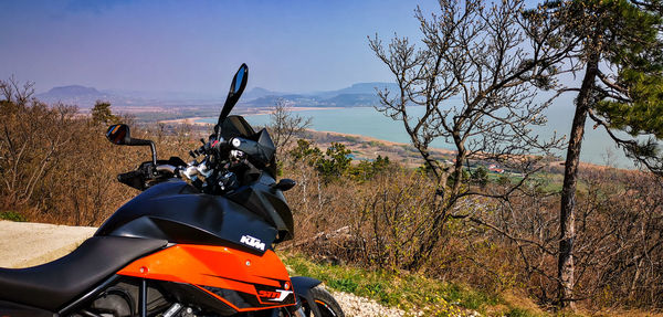 Motorcycle on road amidst trees against sky