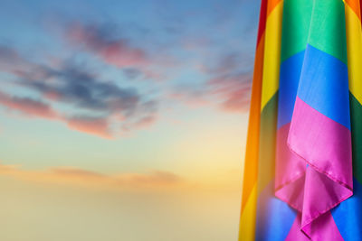 Low angle view of multi colored flags against sky during sunset