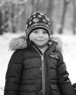 Portrait of smiling boy standing in snow