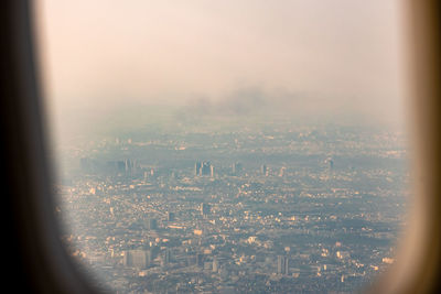Aerial view of city buildings seen through window