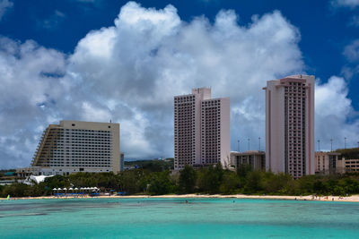 View of swimming pool by buildings against sky