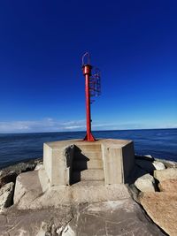 Lifeguard hut on beach against blue sky