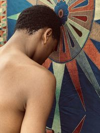 Side view of man resting his head against a wall.