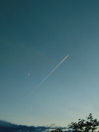 Low angle view of vapor trail against clear blue sky