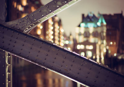 Close-up of illuminated railing against sky at night