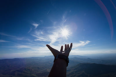 Low angle view of person hand against sky