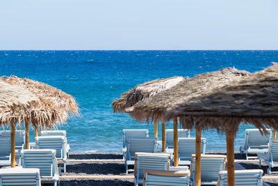 Chairs on beach against clear sky