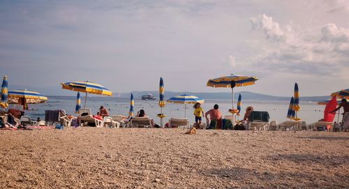 Group of people on beach against sky