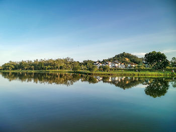 Scenic view of lake by trees against sky