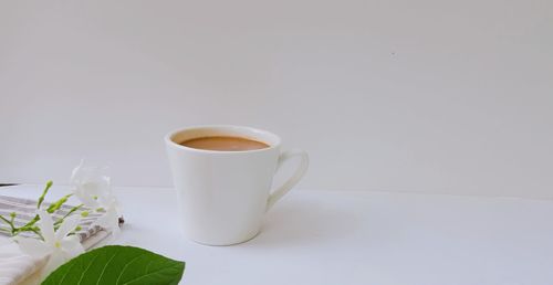 Coffee cup on table against white background