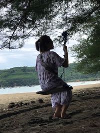 Rear view of woman with arms raised