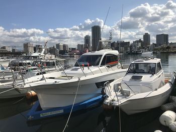 Boats moored at harbor in city