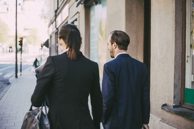 Rear view of business coworkers walking in city