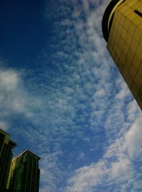 Low angle view of modern building against cloudy sky