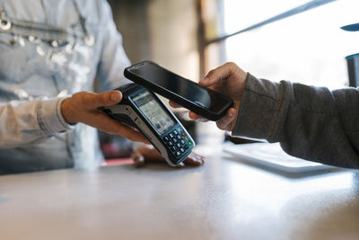 Customer using smart phone for online payment at a bar