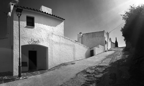 Footpath amidst buildings against sky