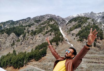 Full length of man standing on mountain against sky