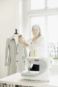 Woman preparing coat on mannequin