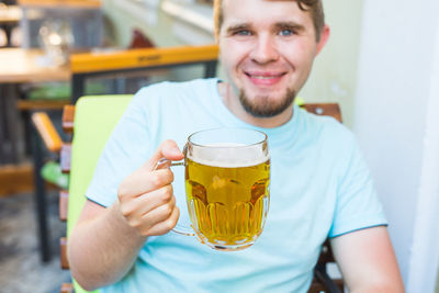 Close-up of woman holding beer in cafe