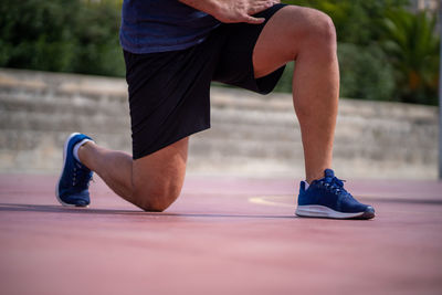 Low section of man wearing shoe