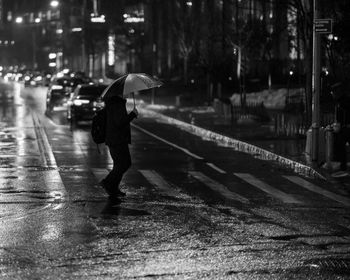 Rear view of man with umbrella on street